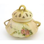 An early 20thC Royal Worcester blush ivory pot pourri decorated with flowers and foliage with