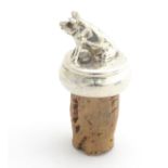 A novelty silver bottle stopper surmounted by a model of a seated pig, with cork stopper. Hallmarked
