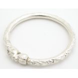 A white metal Indo - Chinese bracelet of bangle form with stylised elephant head detail. Please Note