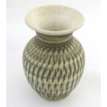 A Bristow studio pottery vase with a flared rim and vertical incised decoration. Marked under b p (