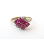 A 9ct gold ring set with 8 red spinel flanked by chip set diamonds. Ring size approx. R 1/2 Please