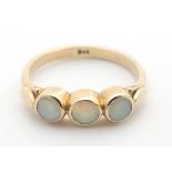 A 9ct gold ring set with three opals. Ring size approx size T Please Note - we do not make reference