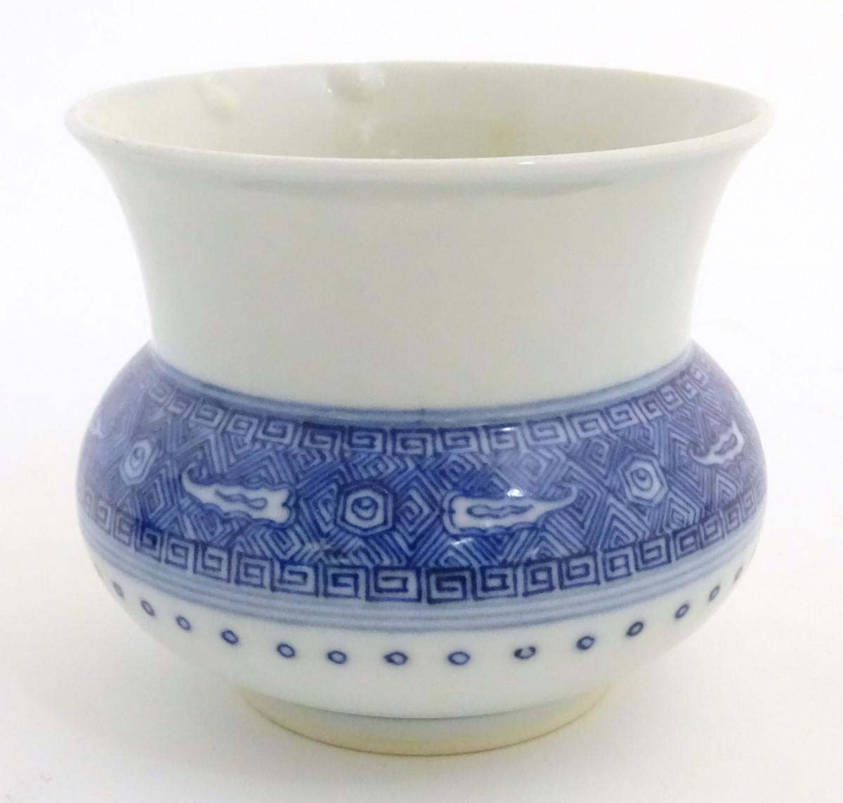 A Chinese pot / vase of squat form with a round body and a flared rim, decorated with banded