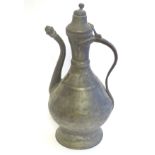 A pewter baluster shaped ewer / pitcher with a spout and a hinged lid, with banded decoration.