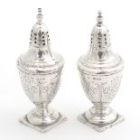 A pair of silver peppetettes of urn shape of square feet. Hallmarked London 1889 maker Brewis &