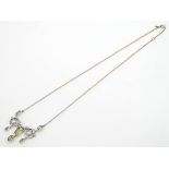 A silver and yellow metal necklace, the pendant section set with peridot and pearls. Approx 19" long