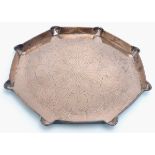 An Arts & Crafts octagonal copper charger / tray with incised natural form decoration and a shaped