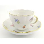 A 19thC Meissen cup and saucer decorated with flowers and gilt highlights. Meissen marks under cup