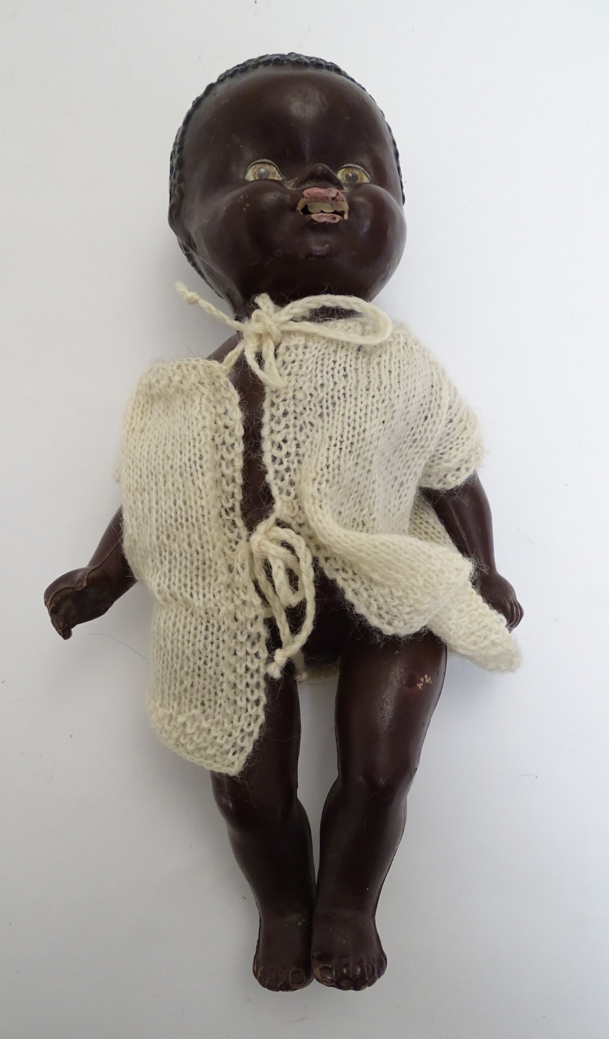 Toy: A black composite doll with articulated head, arms and legs, with modelled hair and painted