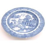 A 19thC blue and white plate decorated in the Willow pattern with a lobed rim. Approx. 9 3/4"