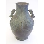 An Oriental bronze baluster shaped vase with banded decoration in relief, character marks and