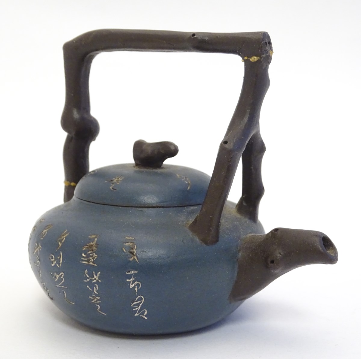 A small Chinese Yixing earthenware / clay teapot and cover with a blue ground, the handle modelled