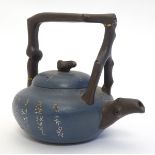 A small Chinese Yixing earthenware / clay teapot and cover with a blue ground, the handle modelled