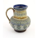 A 19thC Doulton Lambeth jug with a banded floral design in relief by Clara Baker. Doulton Lambeth