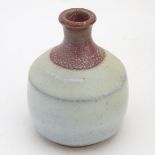 A small two-tone studio pottery bottle vase by Phil Rogers with an ash / nuka glaze. Impressed