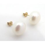 A pair of button pearl stud earrings with 9ct gold shanks. Approx 3/8" diameter Please Note - we