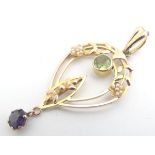A 9ct gold suffragette pendant set with green peridot, white seed pearls and violet amethyst. 1 3/4"