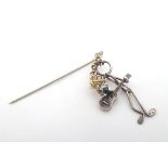 A silver stick pin decorated with dangling silver firework guitar playing figure with yellow metal