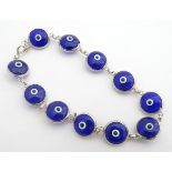 A silver bracelet set with blue and white glass roundels approx 7" long Please Note - we do not make