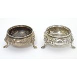A pair of silver salts with embossed floral decoration on 3 legs. Hallmarked London 1869 maker