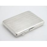 A silver large cigarette case with engine turned decoration and gilded interior. Hallmarked