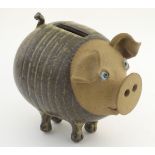 A 20thC Muggins studio pottery flatback piggy bank formed as a pig with a salt glaze finish.