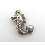 A mid 20thC white metal pendant formed as a Georgian dolphin / serpent. ( unmarked - tests as