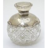 A cut glass dressing table bottle with engraved silver mounts and top hallmarked Chester 1906