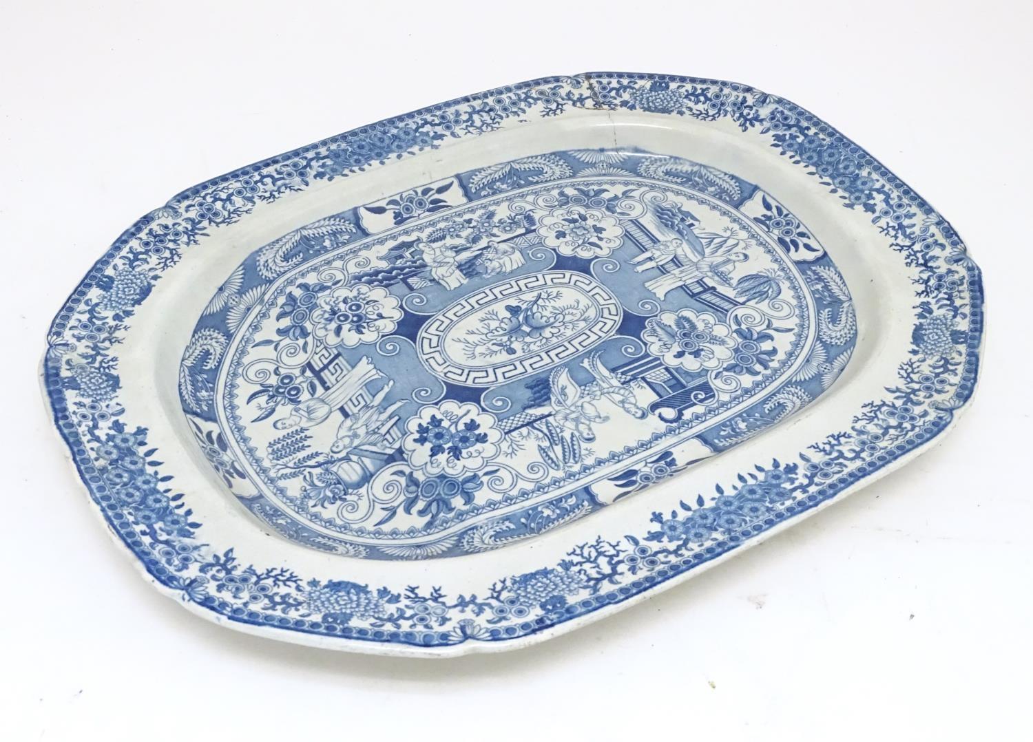 A 19thC blue and white tree and well meat plate, with panelled decoration depicting figures on