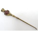 An early 20thC gilt metal button hook with an ornate handle, with a Scottish agate sphere enclosed