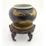 A Japanese jardiniere / planter with a bulbous lacquered body decorated with flying cranes
