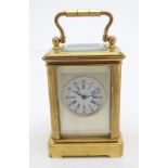 A large 20thC carriage clock of glit metal and bevelled glass construction, with a white enamel dial