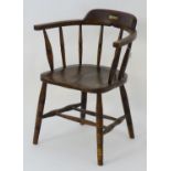 A late 19thC smokers bow chair with ring turned supports and standing on legs united by a double