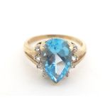 A 9ct gold ring set with pear cut topaz flanked by white stones. Ring size approx. R 1/2 Please Note