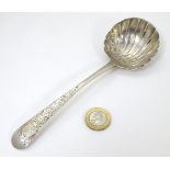 An Irish silver sauce ladle with shell formed bowl and engraved decoration to handle. Dublin,