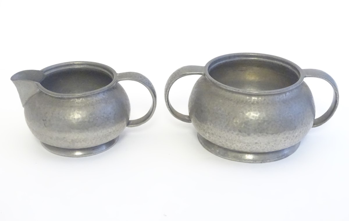 An early 20thC pewter milk jug and sugar bowl designed by Archibald Knox for the Tudric range by