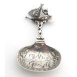 A Dutch silver caddy spoon with cast boat desecration to handle ans and swans in landscape to bowl