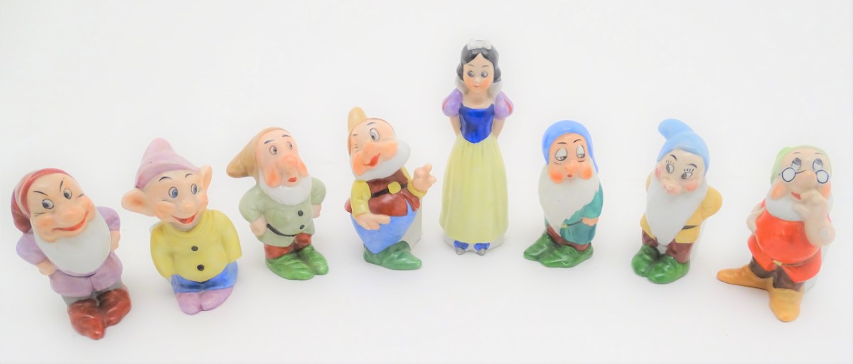 A mid-20thC ceramic novelty set of bud vases, formed as Snow White and the seven Dwarves. The