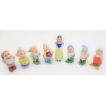 A mid-20thC ceramic novelty set of bud vases, formed as Snow White and the seven Dwarves. The