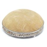 A circular, domed pin cushion with a silver base, hallmarked Birmingham 1919, maker Levi &