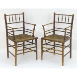 A pair of late 19thC Arts & Crafts Sussex chairs designed by Phillip Webb for Morris & Co. The