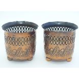 A pair of small copper planters with lobed rims, decorative reticulated banding and embossed acorn