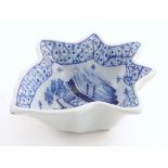 An 18thC Delft blue and white pickle dish of vine leaf form, decorated with a handpainted pagoda