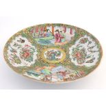A Chinese Cantonese famille rose plate with panelled decoration depicting figures in an interior and