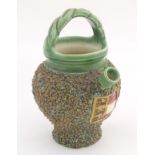 A small jug with a green ground spout and over handle. The textured body decorated with an