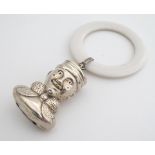 A silver rattle formed as the head of a comical figure with ivorine teething ring. Hallmarked