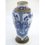 A Chinese blue and white baluster vase depicting figures in a landscape, with incised banded