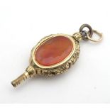 A 19thC yellow metal watch key, the central section set with carnelian seal with engraved