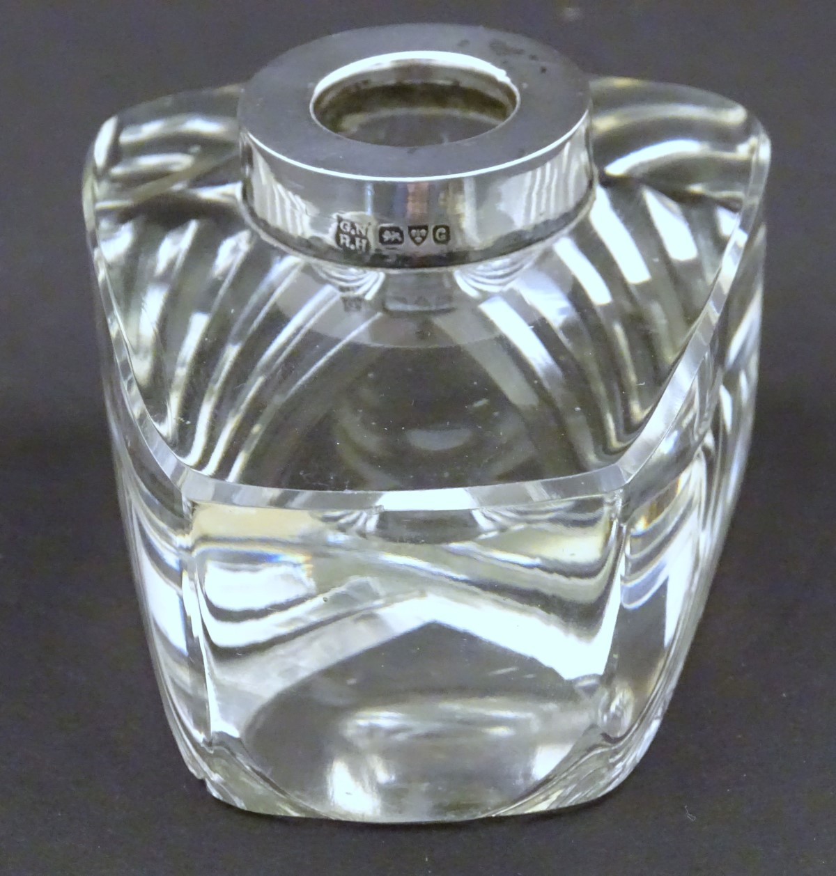 An early-20thC lead glass inkwell, the base with mitre cut decoration, silver rim hallmarked 1903