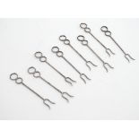 A set of 8 white metal cocktail / olive forks. 3" long Please Note - we do not make reference to the